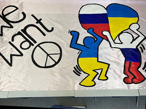 Anti-Kriegsbanner mit ukrainischer und russischer Flagge und Aufschrift "We want Peace"