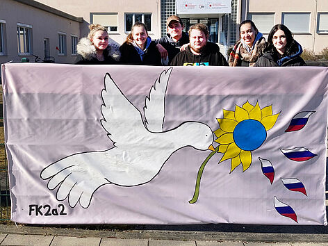 Anti-Kriegsbanner mit ukrainischer und russischer Flagge und Friedenstaube